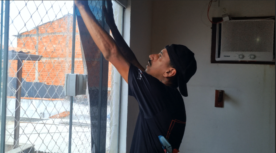 Profissional aplicando película em um vidro residencial